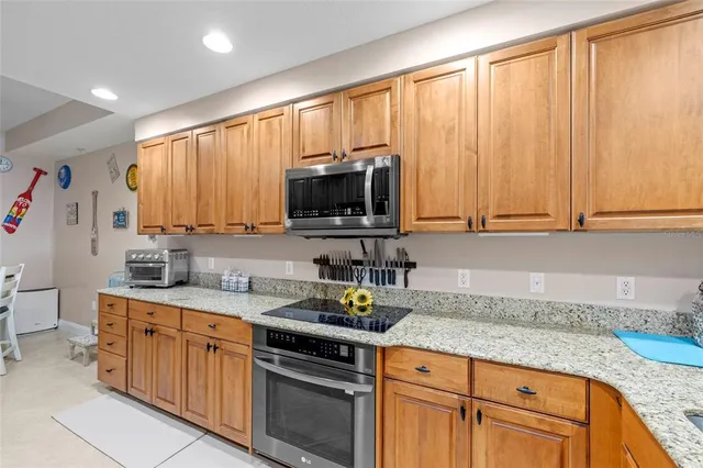 a kitchen with stainless steel appliances granite countertop a sink a stove and cabinets