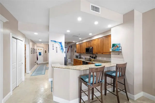 a kitchen with a dining table chairs refrigerator and a sink