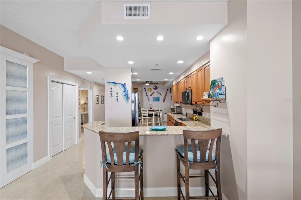 615 Riviera Dunes Way, Unit 204 Palmetto, FL 34221 - Photo 10 of 43 a kitchen with a dining table chairs and refrigerator