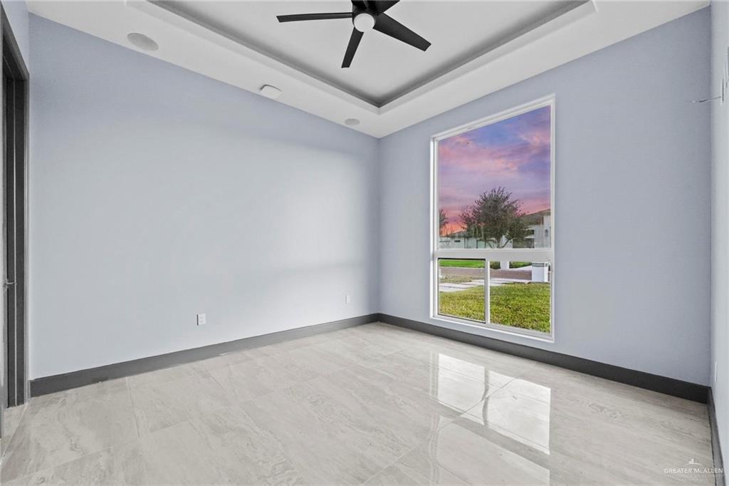 2321 Martha's Lane Mission, TX 78573 - Photo 25 of 36 Empty room featuring a raised ceiling and ceiling fan