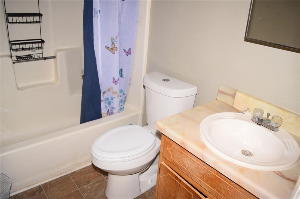 705 Triune Mill Road Thomaston, GA 30286 - Photo 26 of 39 a bathroom with a sink a toilet and shower curtain