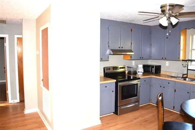 a kitchen with stainless steel appliances granite countertop a sink a stove and cabinets