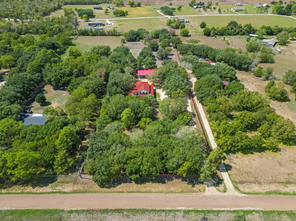 an aerial view of residential houses with outdoor space and trees