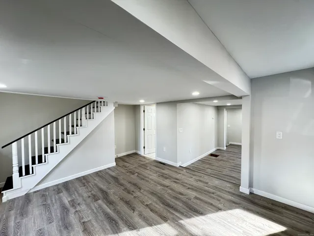a view of a hallway with wooden floor and staircase