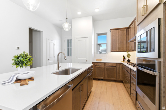 7243 West Terraine Road West Jordan, UT 84081 - Photo 10 of 31 Modern kitchen featuring a large island with an undermount sink and a built-in dishwasher