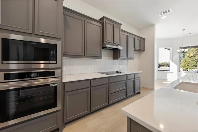 a kitchen with stainless steel appliances a stove microwave and cabinets