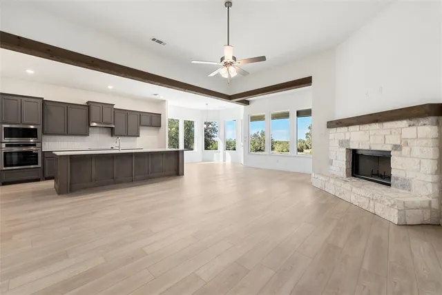 a large white kitchen with a large window a oven and kitchen island