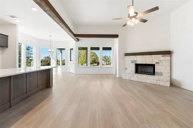wooden floor fireplace and windows in an empty room