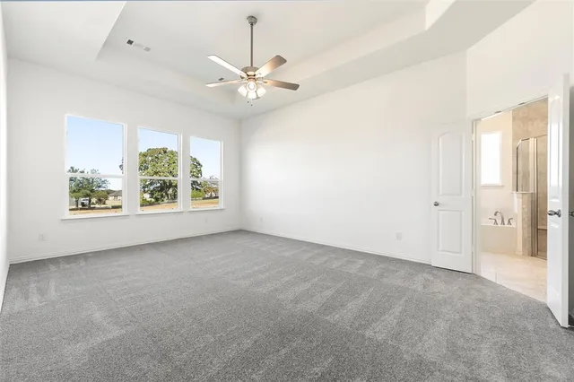 an empty room with chandelier fan