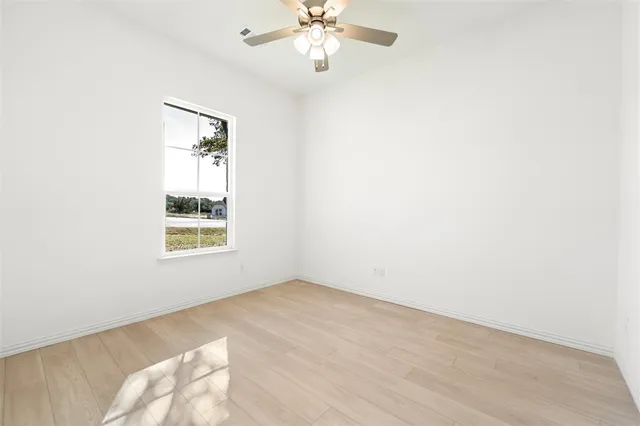 an empty room with a window and a fan