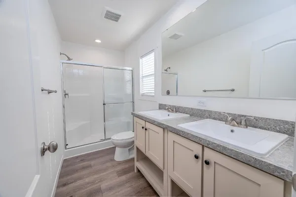 a bathroom with a granite countertop sink toilet and shower