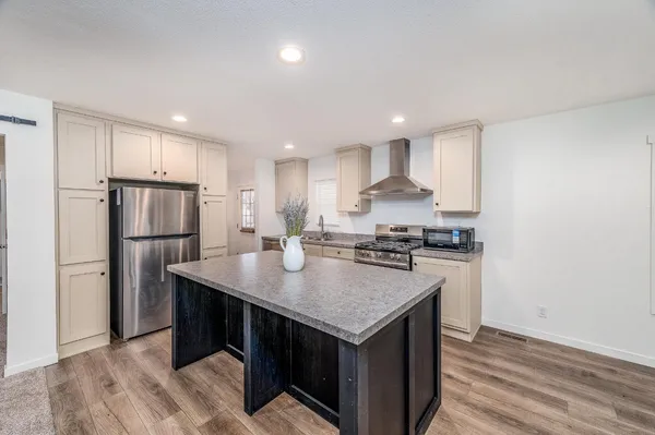 a kitchen with kitchen island a sink stove and refrigerator