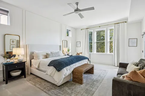 a bathroom with a bathtub shower sink vanity mirror and toilet