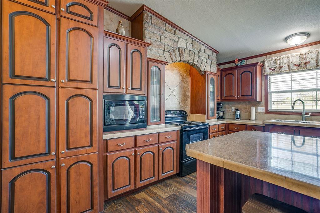 321 Young Road Millsap, TX 76066 - Photo 13 of 28 a kitchen with stainless steel appliances granite countertop a stove and a sink