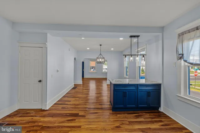 a view of a hallway with front door and wooden floor