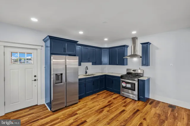 a kitchen with stainless steel appliances granite countertop a refrigerator stove and sink
