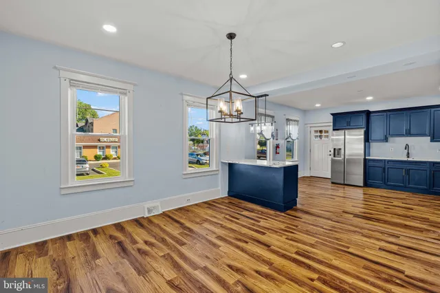 a kitchen with stainless steel appliances granite countertop a sink window and wooden floor