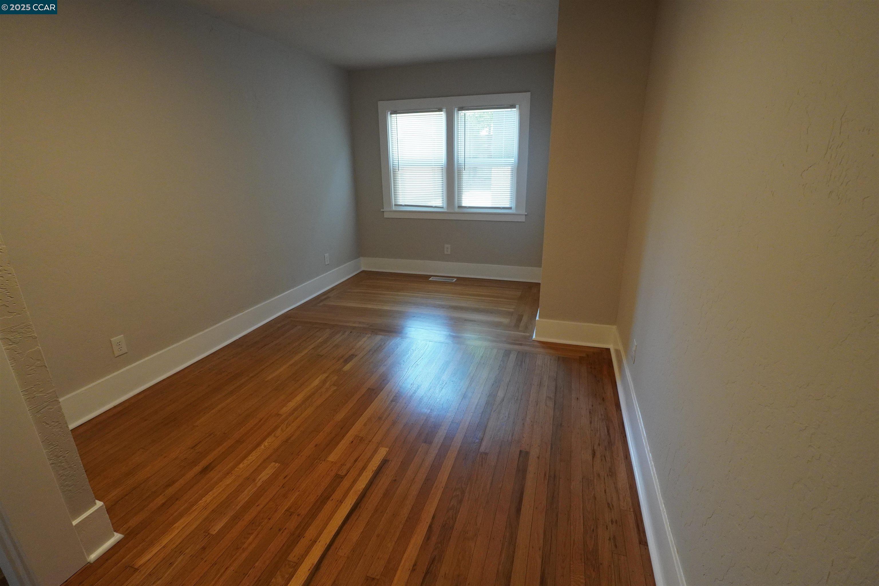 2645 Maxwell Avenue Oakland, CA 94619 - Photo 11 of 19 an empty room with wooden floor and windows