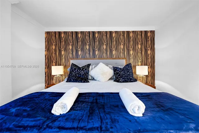 a large bed sitting in a bedroom next to a window with wooden floor