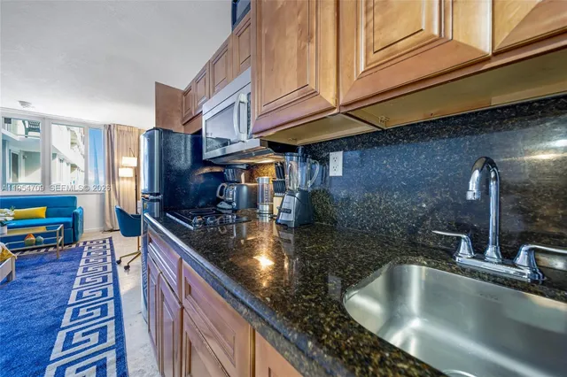 a kitchen with stainless steel appliances granite countertop a sink a counter space and cabinets