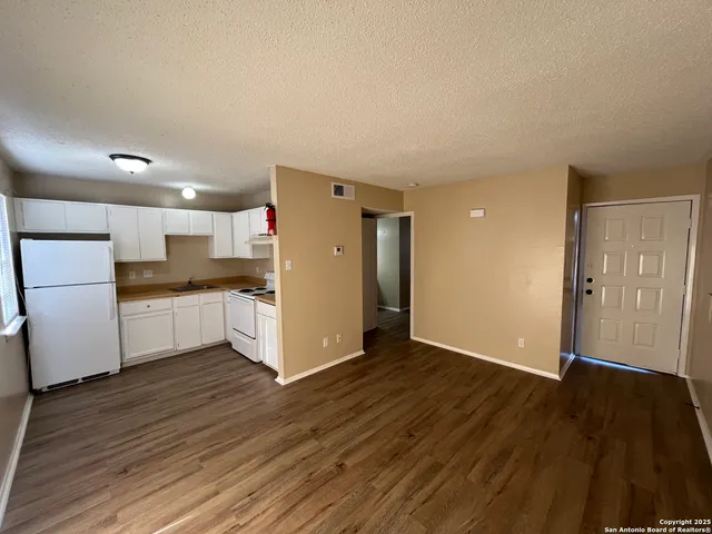 a view of kitchen with refrigerator and wooden floor