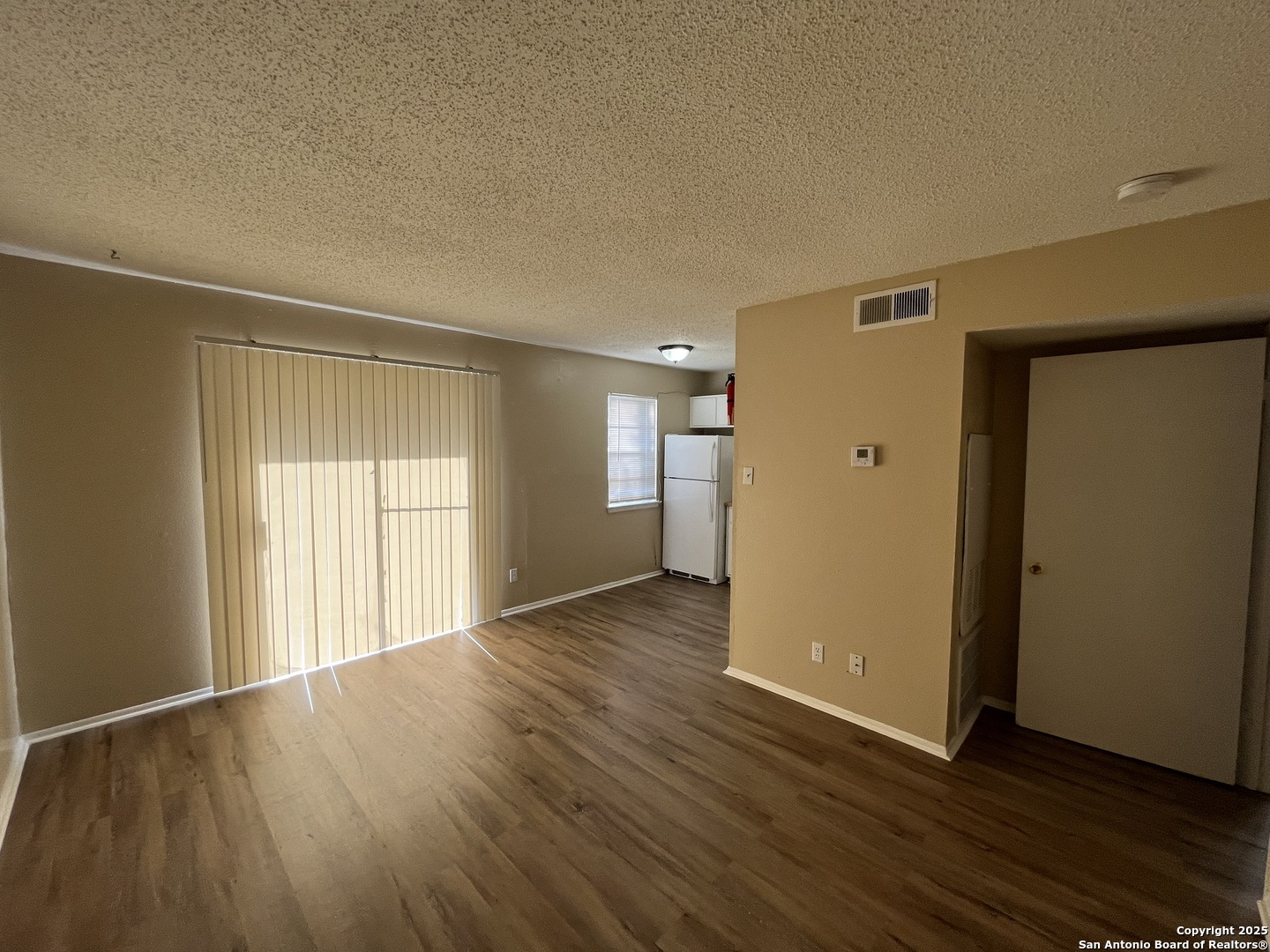 300 Moursund Boulevard, Unit 9 San Antonio, TX 78221 - Photo 3 of 10 a view of an empty room with wooden floor and a window