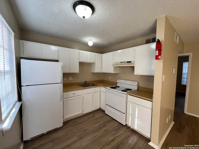 a kitchen with white cabinets and white appliances
