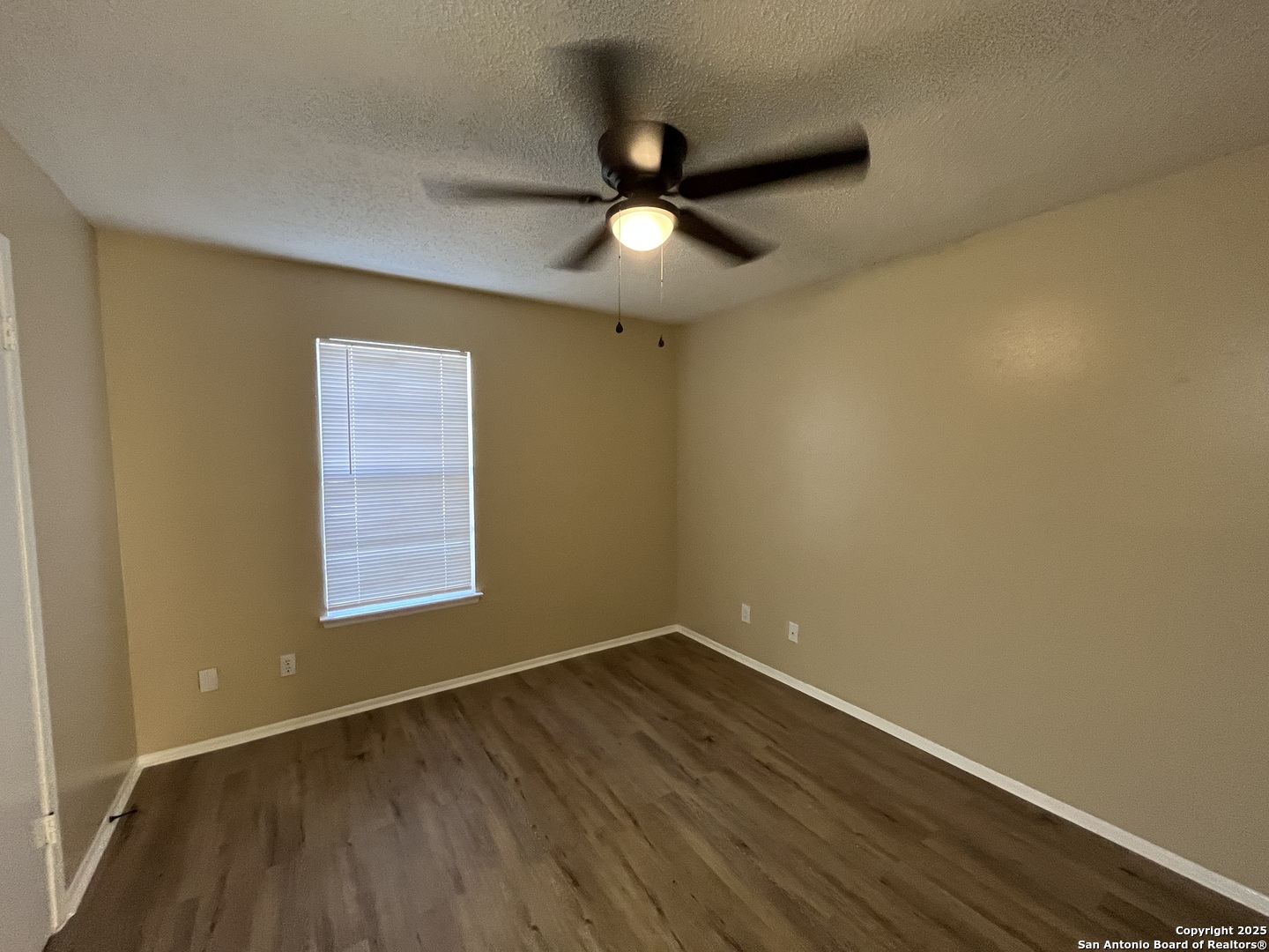 300 Moursund Boulevard, Unit 9 San Antonio, TX 78221 - Photo 6 of 10 a view of an empty room with wooden floor and a window