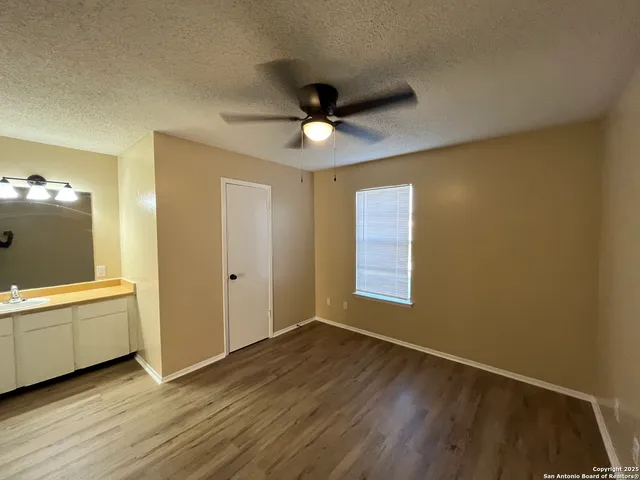 a view of a livingroom with a chandelier fan and windows
