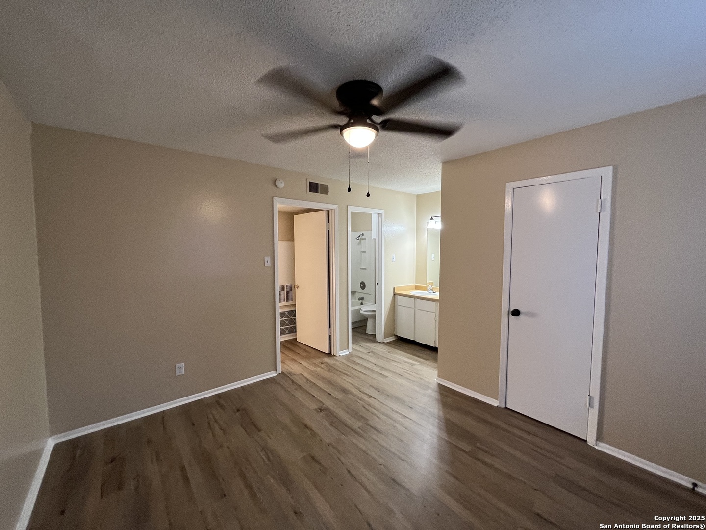 300 Moursund Boulevard, Unit 9 San Antonio, TX 78221 - Photo 8 of 10 an empty room with wooden floor and a ceiling fan