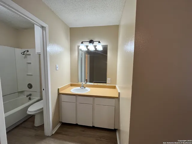 a spacious bathroom with a granite countertop sink a toilet and shower