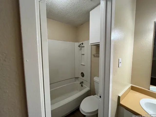 a bathroom with a granite countertop toilet a sink and bathtub