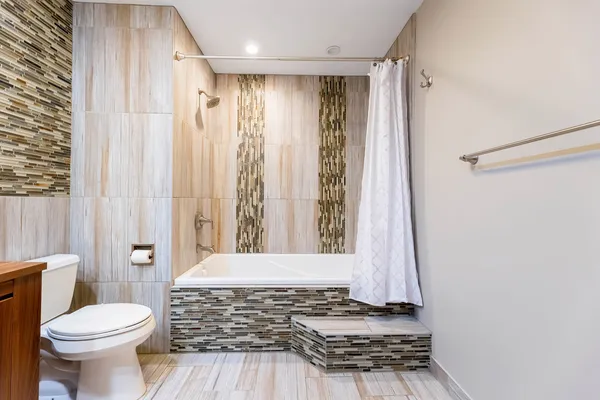 a bathroom with a toilet a window and shower