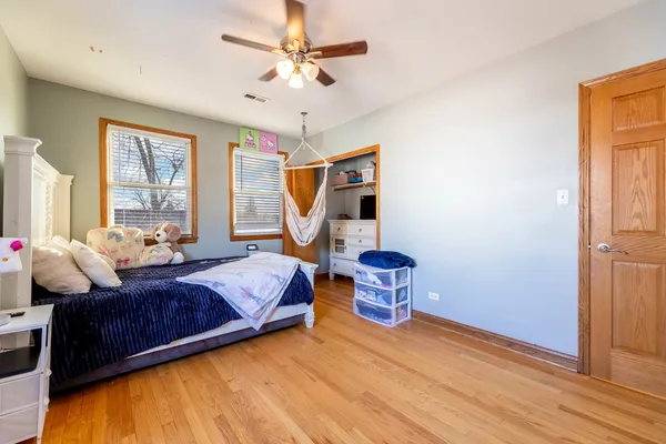 a bedroom with a bed and wooden floor