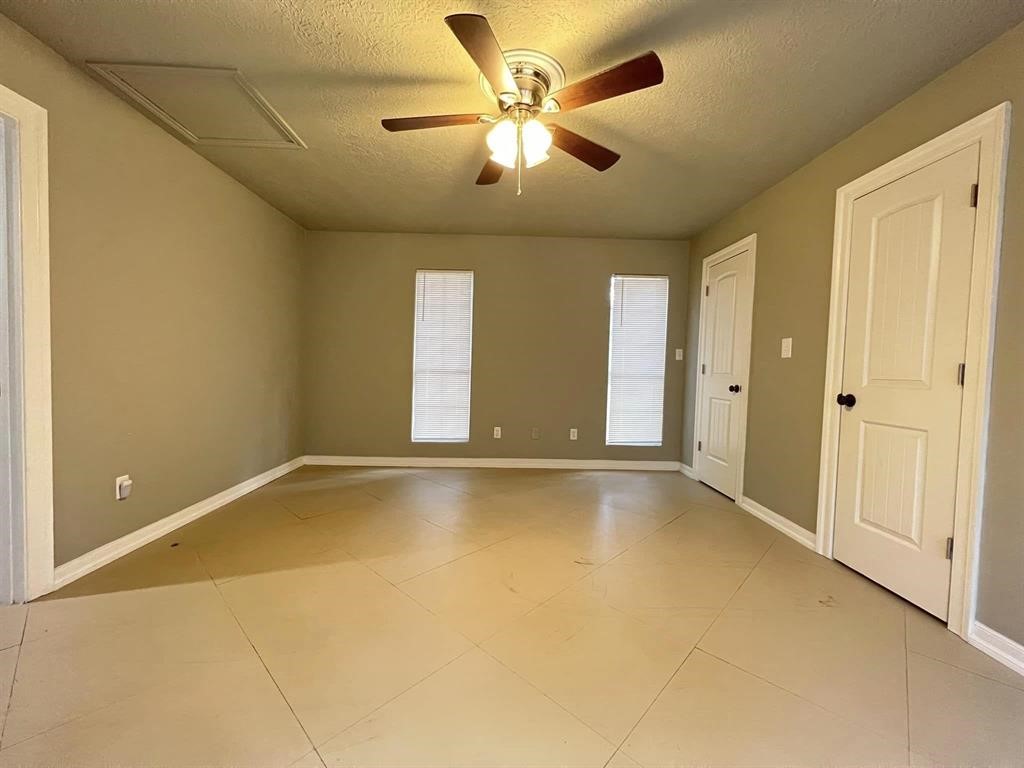 123 Pinehurst Drive Sour Lake, TX 77659 - Photo 11 of 23 a view of an empty room with window and a ceiling fan