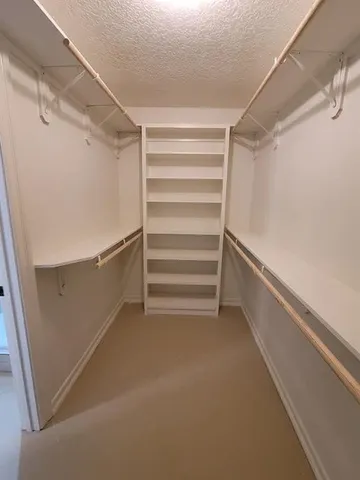 a view of walk in closet with empty racks