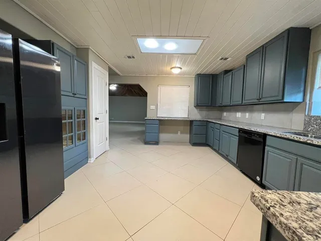 a kitchen with stainless steel appliances kitchen island granite countertop a refrigerator and a sink