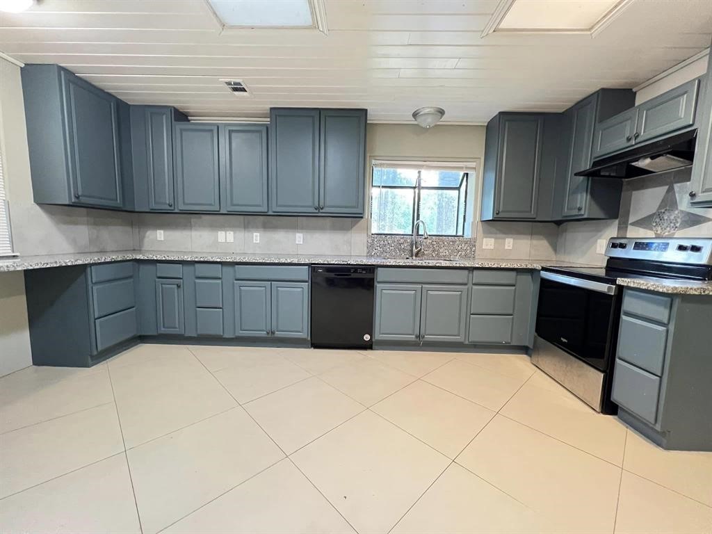 123 Pinehurst Drive Sour Lake, TX 77659 - Photo 6 of 23 a kitchen with stainless steel appliances granite countertop a sink counter space cabinetry and a window