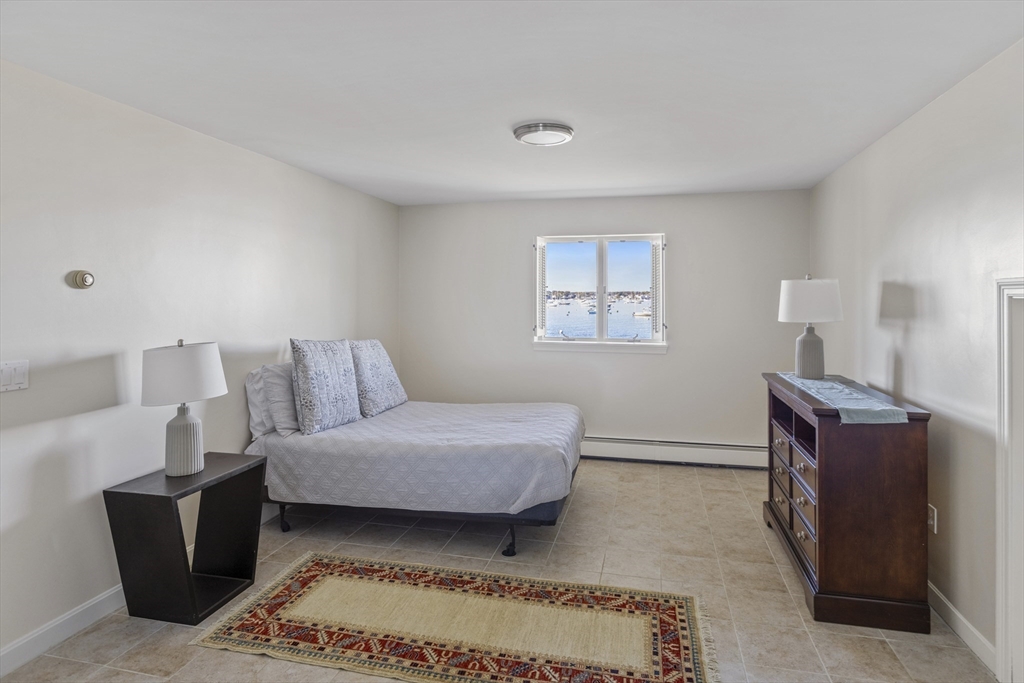 89 Naugus Avenue Marblehead, MA 01945 - Photo 25 of 39 a bedroom with a bed and wooden floor