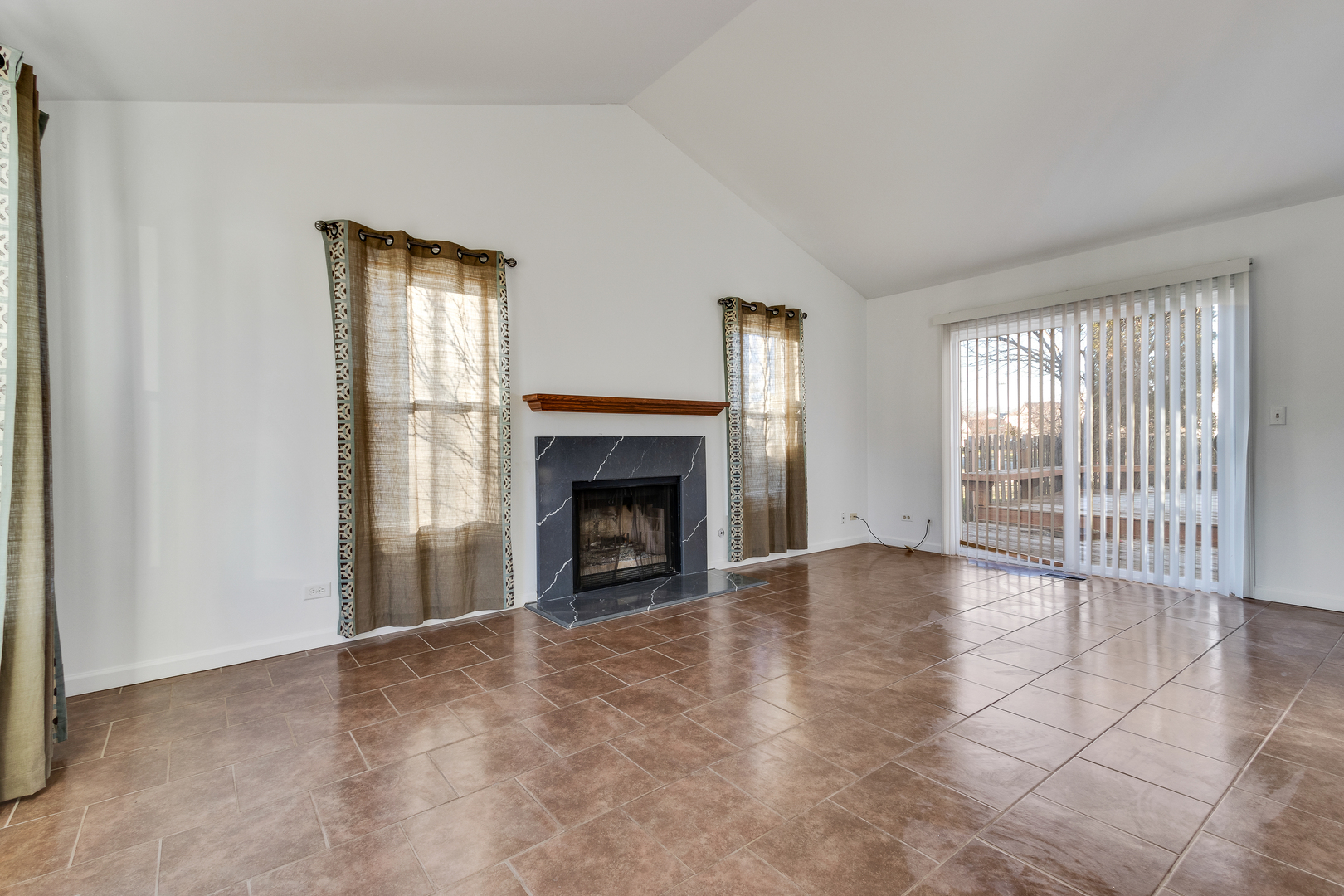 68 Jackson Lane Streamwood, IL 60107 - Photo 4 of 25 an empty room with floor to ceiling window and fireplace