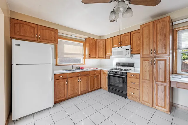 a kitchen with stainless steel appliances granite countertop a refrigerator and a stove top oven