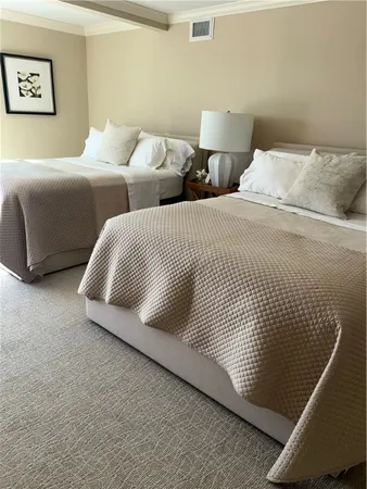 a bedroom with two beds and painting on the wall
