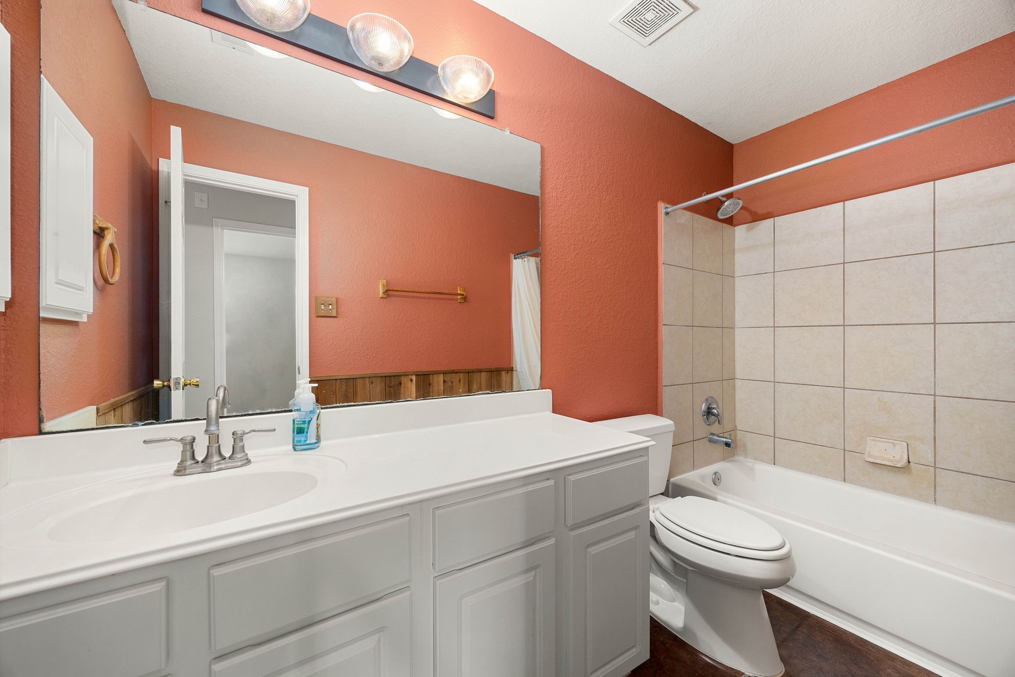 3102 Single Ridge Way Katy, TX 77493 - Photo 7 of 23 Functional and well-appointed secondary bathroom featuring an expansive vanity counter with generous space for everyday essentials. The tile-surround tub and shower combination maximizes usability, while a large vanity mirror helps keep the space open and well-lit.