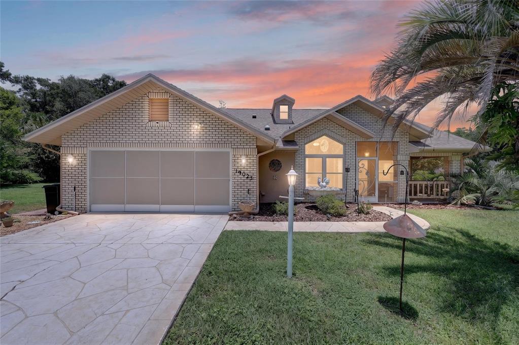 19025 Southwest 98th Loop Dunnellon, FL 34432 - Photo 1 of 80 a front view of a house with a yard and garage