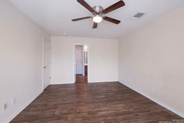 an empty room with fan and a ceiling fan
