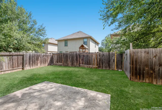 a view of a backyard with wooden fence