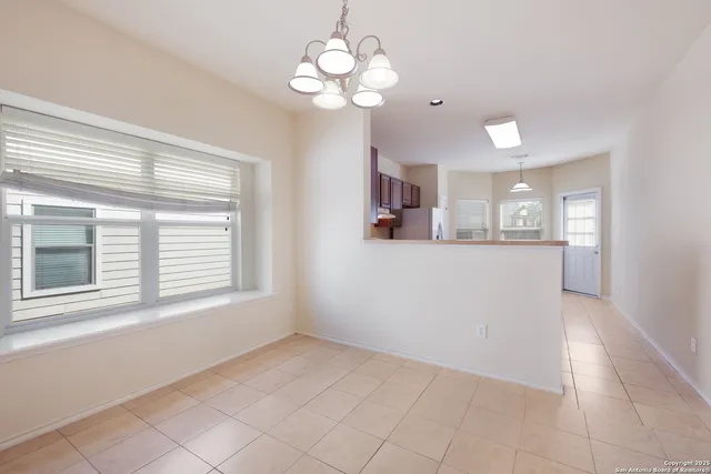 a view of a big room with windows and chandelier