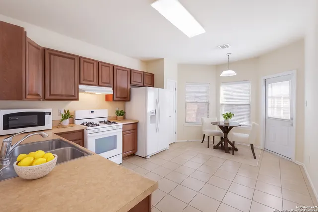 a kitchen with a refrigerator and a stove top oven
