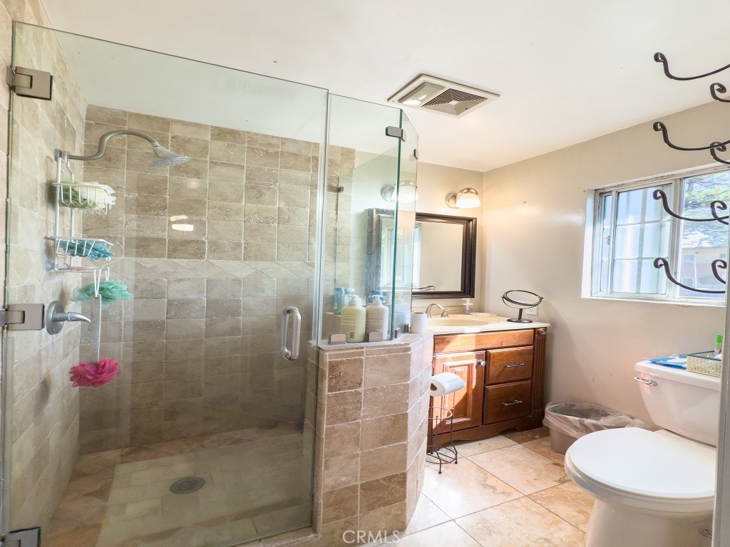 7850 Birchcrest Road Downey, CA 90240 - Photo 14 of 18 a bathroom with a shower sink mirror vanity and toilet