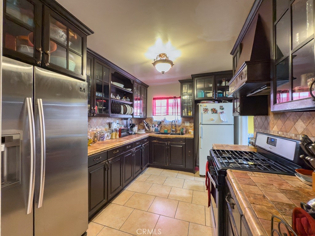 7850 Birchcrest Road Downey, CA 90240 - Photo 9 of 18 a kitchen with stainless steel appliances granite countertop a sink a stove and a refrigerator